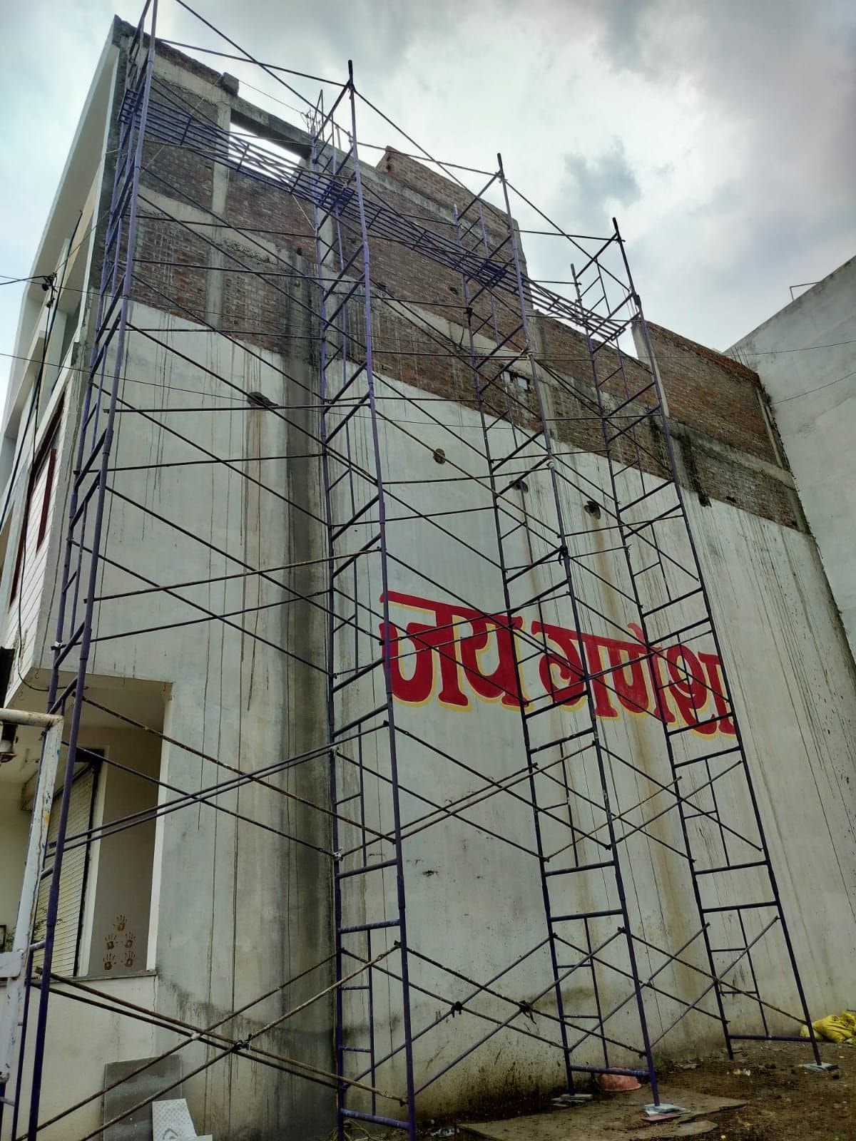 H-frame scaffolding towers with cross bracing against a tall side wall