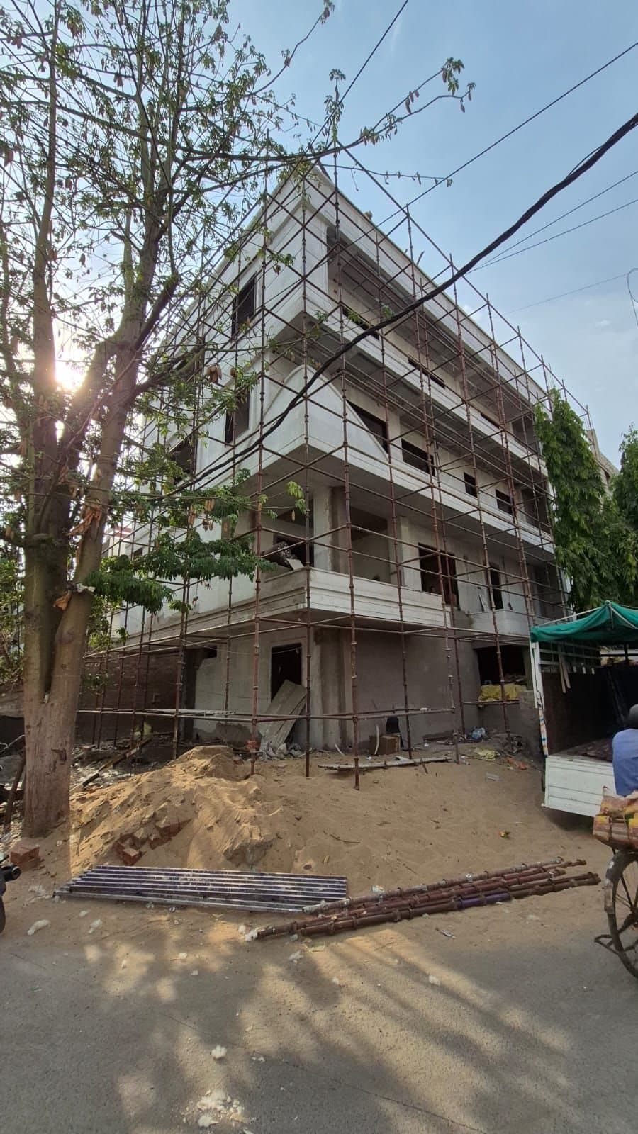 Scaffolding erected around a new four-storey residential building on a corner plot