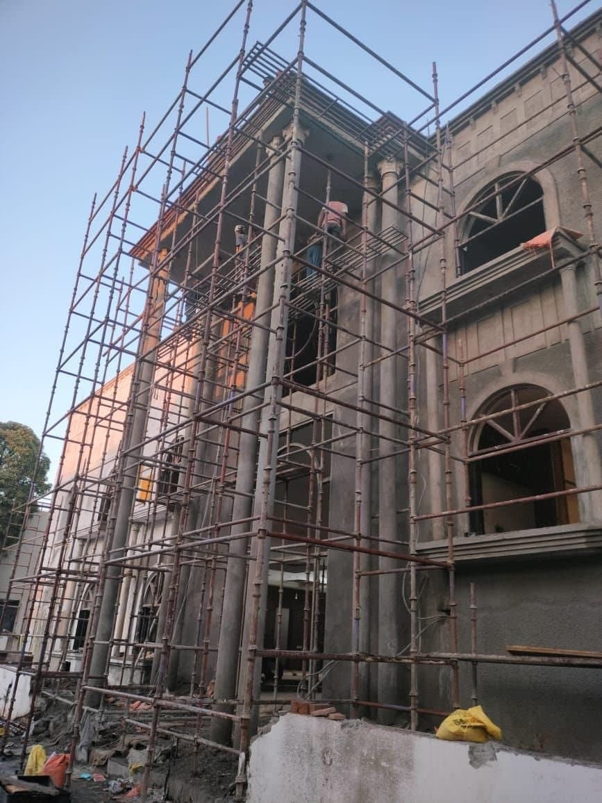Scaffolding around the columns and arched windows of a large villa under construction