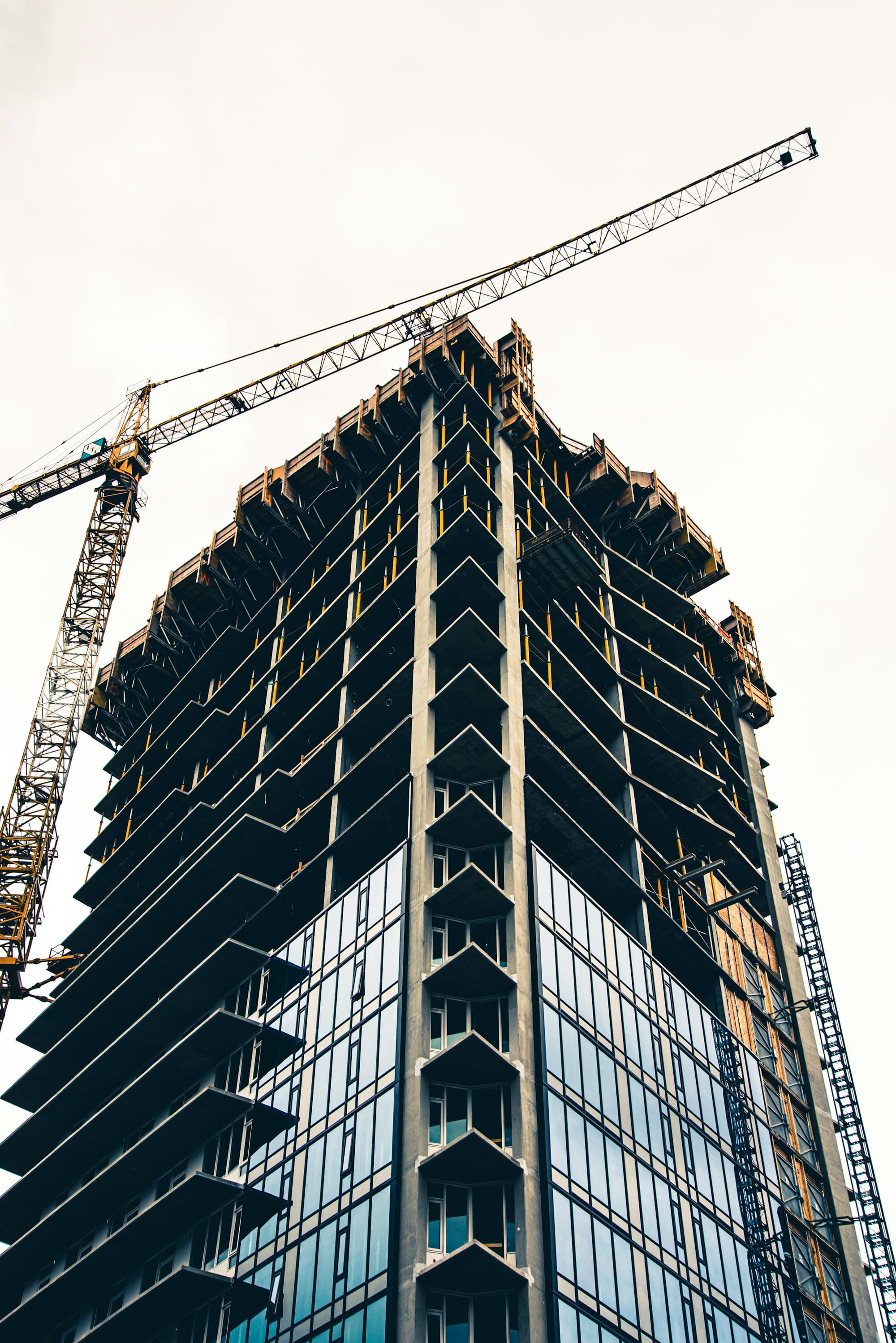 Tower crane beside a glass high-rise under construction