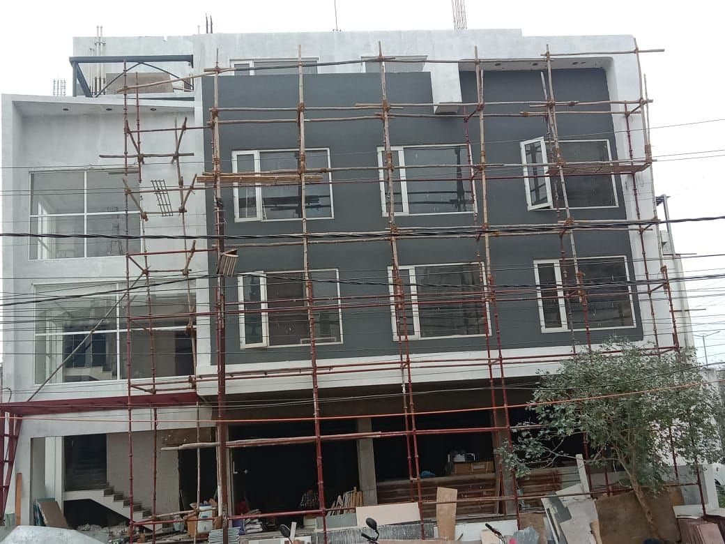 Cup-lock scaffolding in front of a new commercial building with grey facade
