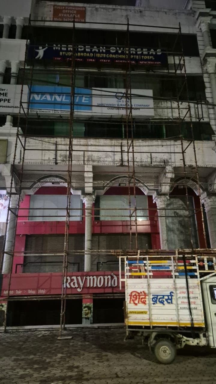 Scaffolding erected overnight in front of a multi-storey shopfront