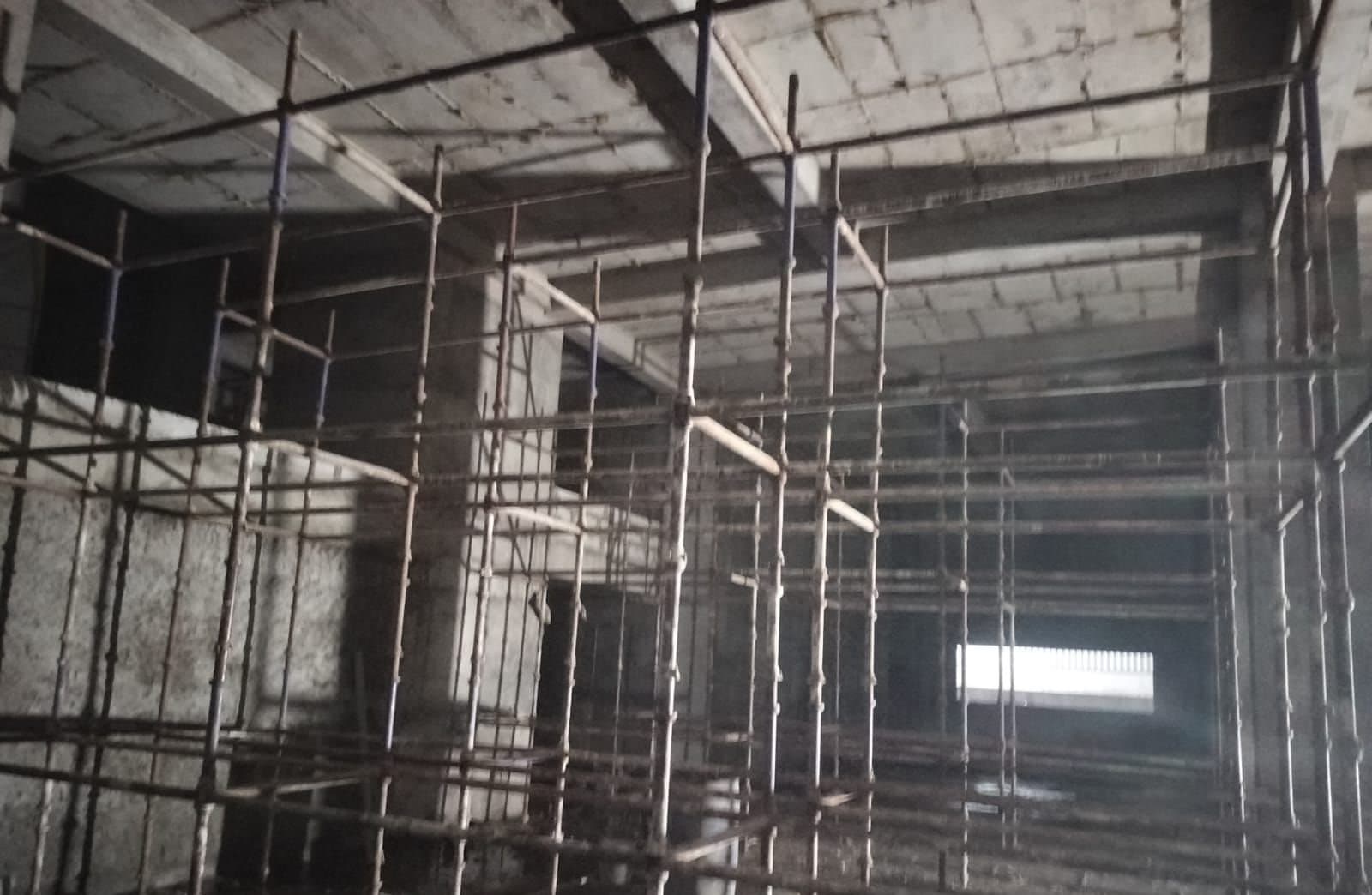 Cup-lock staging supporting a concrete slab inside a building under construction in Indore